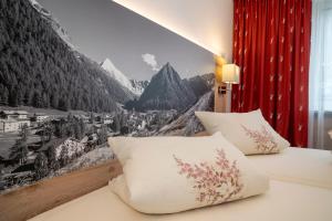 een slaapkamer met 2 bedden en een muurschildering van de bergen bij Cristal Appartementhaus in Samnaun