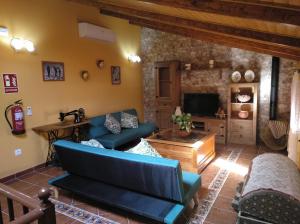 ein Wohnzimmer mit einem Sofa und einem TV in der Unterkunft Casa Rural La Santiaga in Arroyo de la Luz