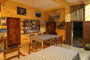 a room with a table and chairs in a library at Hotel Finlanka in Hikkaduwa