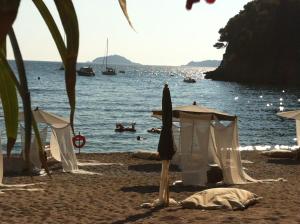 a beach with umbrellas and people in the water at Eco del Mare in Lerici