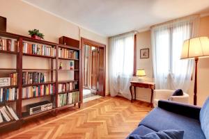 ein Wohnzimmer mit Bücherregalen und einer blauen Couch in der Unterkunft CasaMisa Formosa 5193 in Venedig