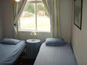 two twin beds in a room with a window at Toms Cabin in Herolds Bay +17 photos