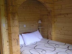 フォート・ウィリアムにあるChalet Blaichの木製の部屋にベッド1台が備わるベッドルーム1室があります。
