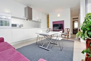 una cucina e un soggiorno con tavolo e divano viola di Piazza del Popolo Apartment a Roma