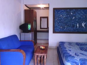 a living room with a blue couch and a table at Gazebo Beach Hotel in Sanur