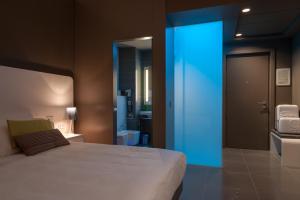 a bedroom with a white bed and a blue light at 8Piuhotel in Lecce