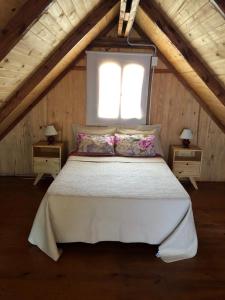 1 dormitorio con cama blanca y ventana en Cabañas Rosmar en Colón