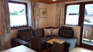 a living room with a couch and two windows at Haus Elisabeth in Mittersill