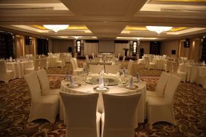a banquet hall with white tables and white chairs at Shanghai Hongqiao Airport Hotel - Air China in Shanghai