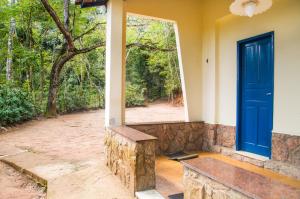 a blue door and a bench in front of a house at Hotel Fazenda Caluje in Engenheiro Paulo de Frontin