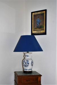 a blue and white vase sitting on a table with a lamp at Les Cimaises du Couvent in Beaune