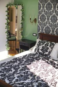 a bed with a black and white comforter and a mirror at Apartment Nostalgie in Opatija