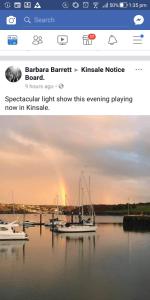 un sitio web con un barco en el agua con un arco iris en Daltons Bar, en Kinsale