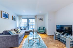 een woonkamer met een bank en een flatscreen-tv bij 2 Bed Executive Apartment next to Liverpool Street FREE WIFI by City Stay Aparts London in Londen