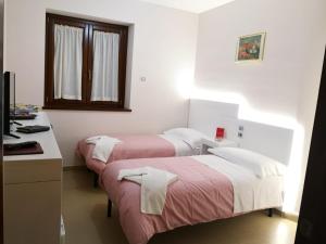 PignolaにあるDa Paolo e Francescaのベッド2台、デスク、窓が備わる客室です。