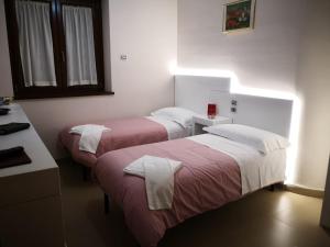 Dos camas en una habitación de hotel con toallas. en Da Paolo e Francesca, en Pignola