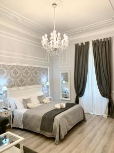 una camera con un grande letto e un lampadario a braccio di Charme & Chic Luxury a Roma
