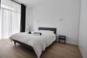 1 dormitorio con cama grande y ventana grande en Rent a Flat - Bruxelles, en Bruselas