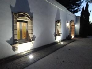 Una casa blanca con luces en el costado. en Masseria Lapica, en Oria