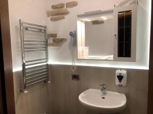łazienka z umywalką i lustrem w obiekcie Garnì Villa Cecilia w mieście Mazzin +37 zdjęć