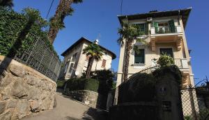 a building with a fence and palm trees in front of it at Apartment Nostalgie in Opatija