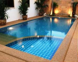 a swimming pool with blue tiles in a building at Katanoi Resort in Kata Beach