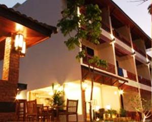 a building with chairs and a table in front of it at Katanoi Resort in Kata Beach
