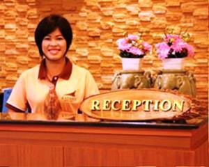 a woman standing behind a podium with a reception sign at Katanoi Resort in Kata Beach +37 photos