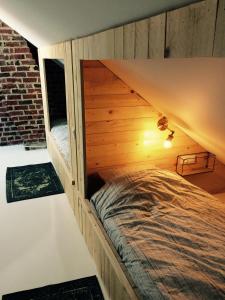 a bed in a wooden room with a roof at Nelly in Ypres