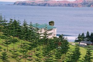 a building on top of a hill with trees at Panorama Seaside Apartments Norfolk Island in Burnt Pine