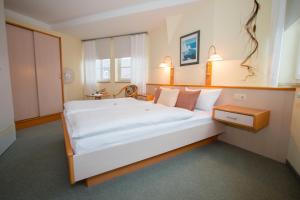 a bedroom with a large white bed in a room at Hotel Garni am Markt in Neustadt bei Coburg