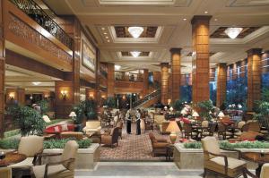 a lobby of a hotel with chairs and tables at Shangri-la Surabaya in Surabaya