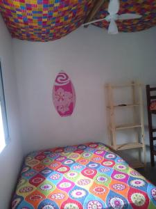 een slaapkamer met een bed met een kleurrijk dekbed bij Chales Bora Bora - Boraceia in Boracéia +49 foto's