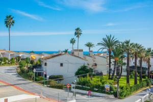 a street with palm trees and a white building at Esmeralda, Pet Friendly, Sea View, Wifi, Near the Beach in La Cala de Mijas