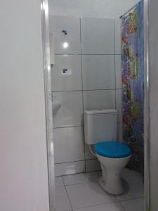 een badkamer met een toilet en een blauwe stoel bij Chales Bora Bora - Boraceia in Boracéia