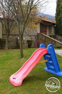 a pink and blue plastic slide in a yard at Villa Luxury Paradise Kastoria in Lithiá