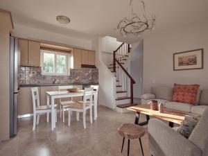 a kitchen and a living room with a table and a staircase at Three Graces Holiday Houses Complex in Laganas