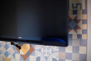 A television and/or entertainment centre at Elisir Suite Rooms by Marino Tourist