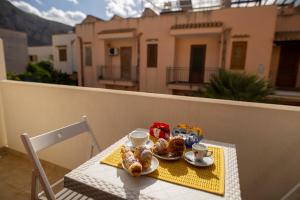 サン・ヴィート・ロ・カーポにあるElisir Suite Rooms by Marino Touristのバルコニーにテーブルと朝食用の食材を用意しています。