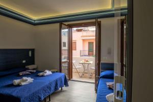 sypialnia z 2 łóżkami i balkonem w obiekcie Elisir Suite Rooms by Marino Tourist w mieście San Vito lo Capo