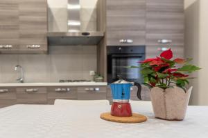une table avec un vase et une fleur dans la cuisine dans l'établissement La Casina Rossa, à Naples