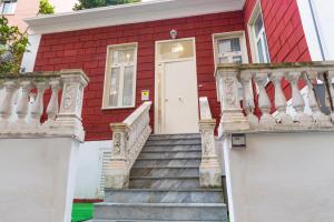 una casa roja con escaleras que conducen a una puerta blanca en La Casina Rossa, en Nápoles