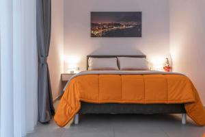 a bedroom with a bed with an orange blanket at La Casina Rossa in Naples