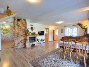 a living room with a fireplace and a table and chairs at Noclegi u Agatki in Ustrzyki Dolne