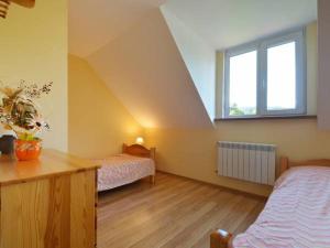 a attic room with two beds and a window at Noclegi u Agatki in Ustrzyki Dolne
