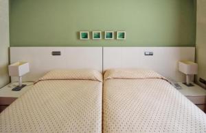 a bedroom with two beds and two lamps at Apartamentos María Luisa in Burgos