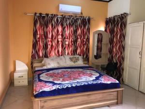 1 dormitorio con cama con dosel y cortinas en Nass Lodge, en Sunyani