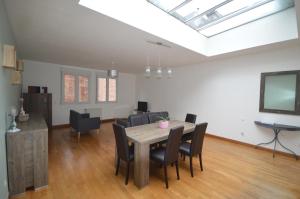 a living room with a dining room table and chairs at La Cotonnerie in Saint-Quentin