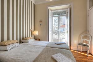 リスボンにあるAngola 1 - 6 Bedroomsのベッドルーム1室(ベッド2台、大きな窓付)
