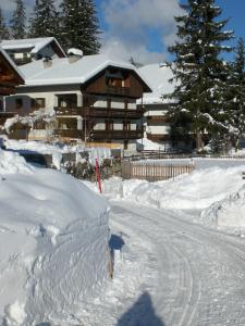a house is covered in snow with a road at CIADIN APPART. in Badia